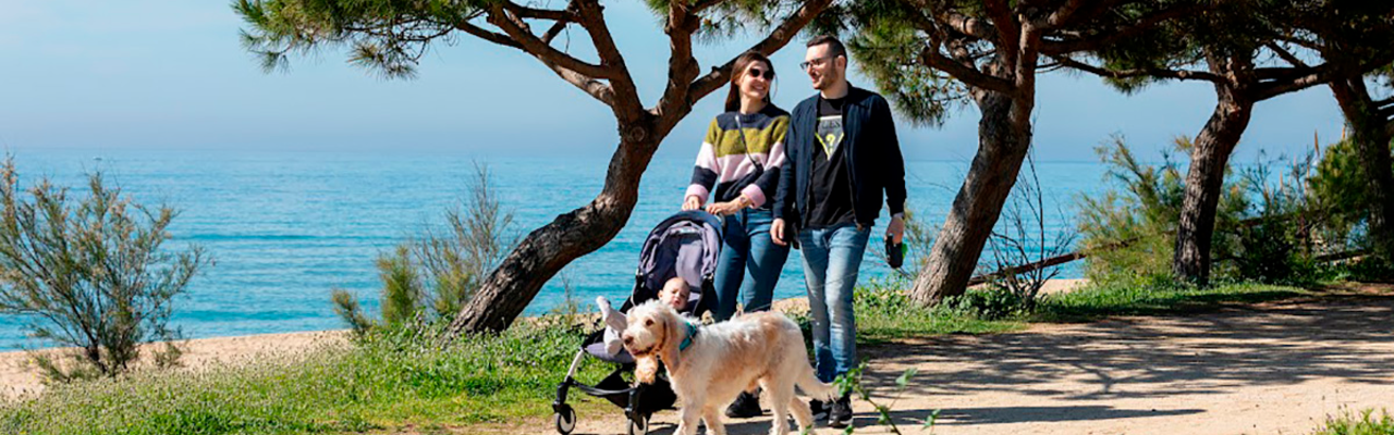 Família passejant amb el gos pel passeig marítim d'Arenys de Mar