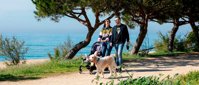 Família passejant amb el gos pel passeig marítim d'Arenys de Mar