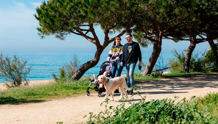 Família passejant amb el gos pel passeig marítim d'Arenys de Mar